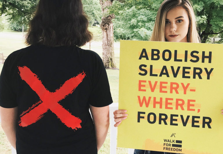 abolish slavery every-where forever. Girl holding a yellow poster at the walk for freedom.